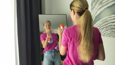una mujer limpiando un espejo.