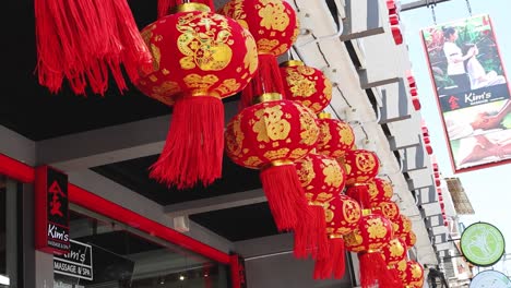 a row of decorative red lanterns adorns a city street, creating a festive atmosphere.