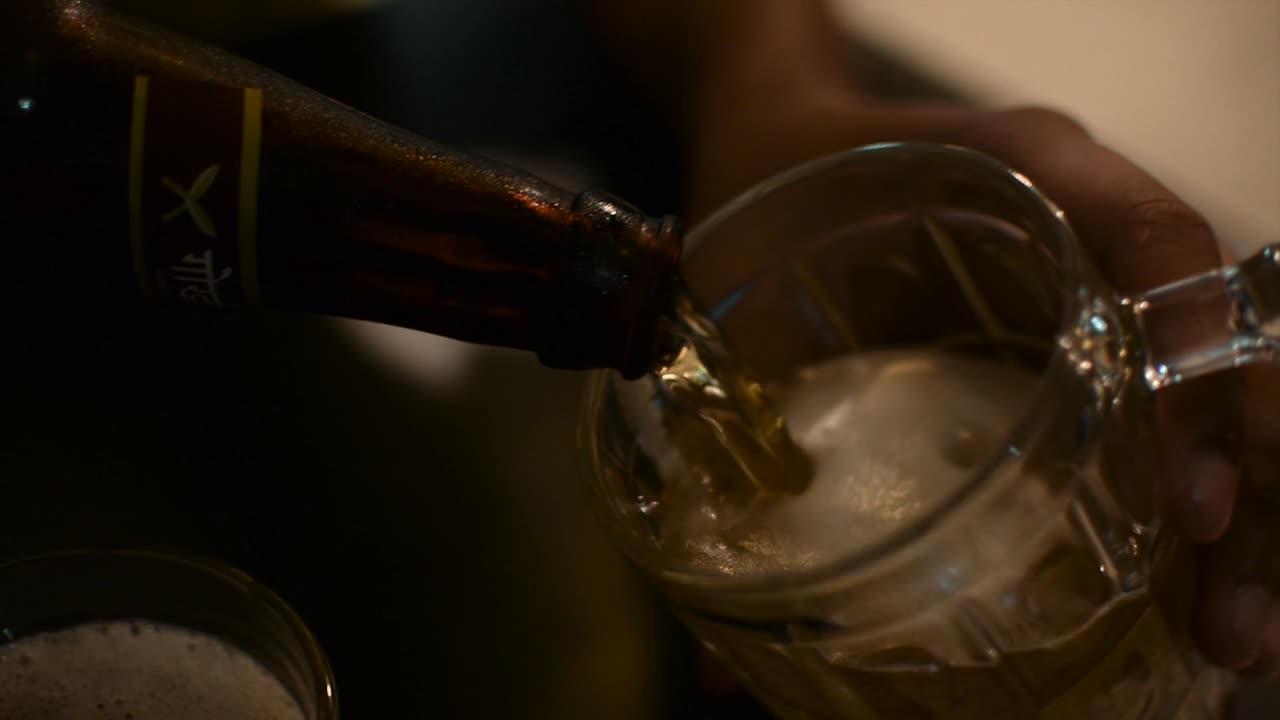 vertiendo un vaso de cerveza de una botella
