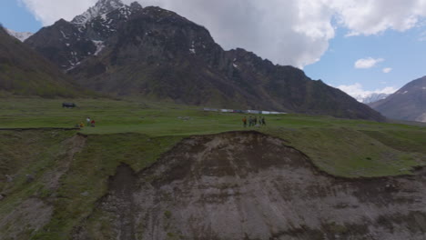 aerial push out shot people on a ledge with a mountain range in the background