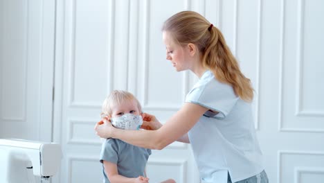 mother and daughter helping a child wear a mask