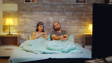 caucasian couple using tv remote control