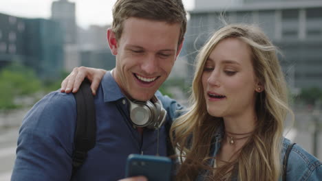 portrait of happy young caucasian couple in city posing making faces taking photo using smartphone enjoying urban travel lifestyle