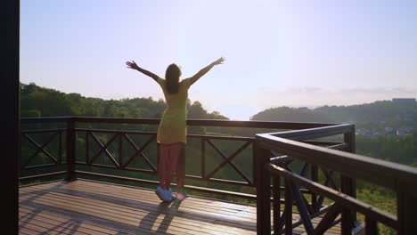 woman enjoying a sunset view from a balcony