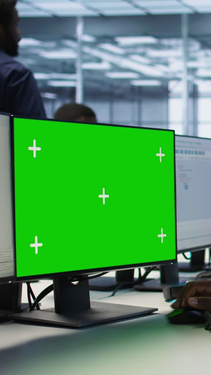 Vertikal video: Mand arbejder i serverfarm med green screen-computer