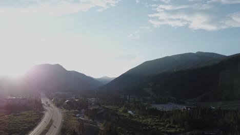 aerial shot pushing towards the mountains as sunbeams break across the summit