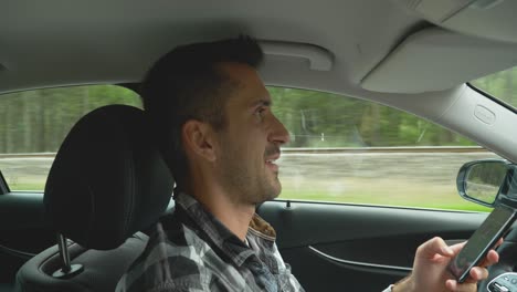 hombre hablando por teléfono mientras conduce, mira por el espejo retrovisor, pasa el auto