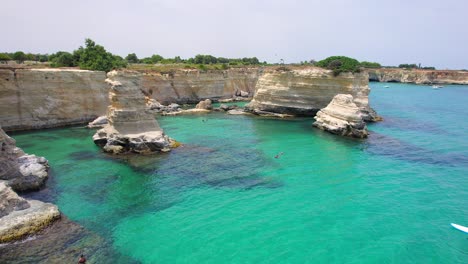 4K-aerial-of-the-rock-formations-of-Sant'Andrea-near-Torre-Dell'Orso,-Apulia,-Italy-in-the-summer