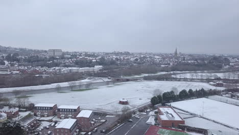 Track-backwards-drone-shot-of-snowy-Exeter-over-the-River-Exe