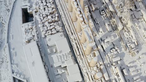 Aerial-view-overlooking-details-of-the-snow-covered-Parthenon-ruins-and-snowy-forest,-rare-winter-day-in-Athens,-Greece