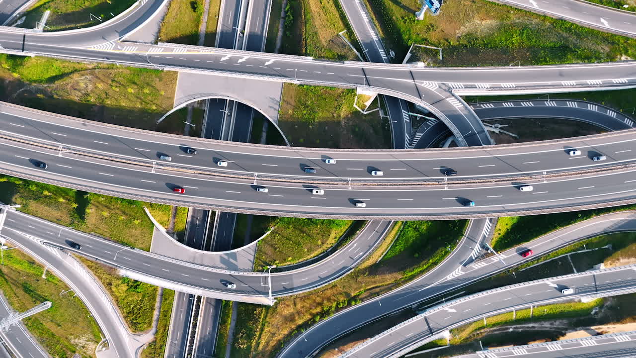 Rising over the complicated road conjunction with cars moving by. Highways, loops and freeways from top view.