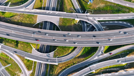 rising over the complicated road conjunction with cars moving by. highways, loops and freeways from top view.
