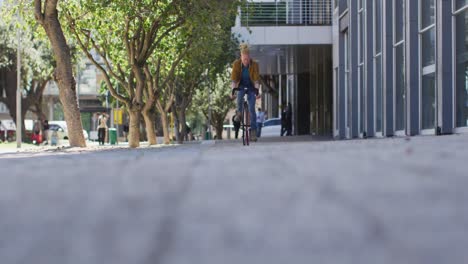 hombre albino afroamericano con dreadlocks montando en bicicleta en la calle