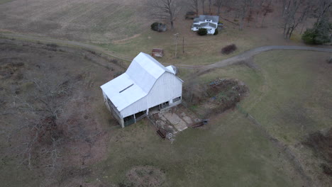 white barn with grass field aerial drone footage