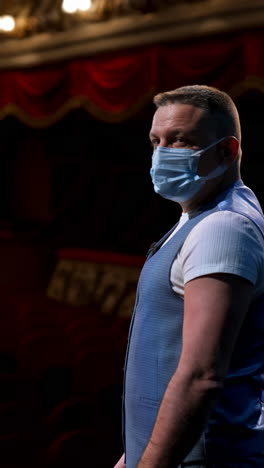 man in mask at theatre. man in protective face mask performs on stage