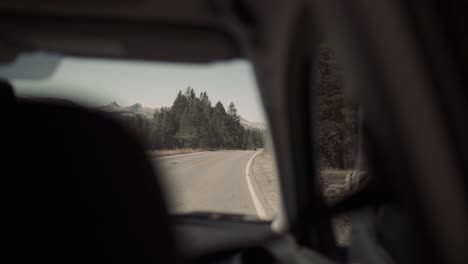 Inside-back-seat-of-car-driving-down-long-winding-road-in-summer-in-Yosemite-National-Park