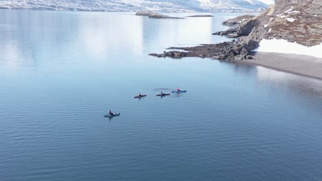 kayakistas flotando tranquilamente en agua sin olas en el sereno fiordo reydarfjordur, antena