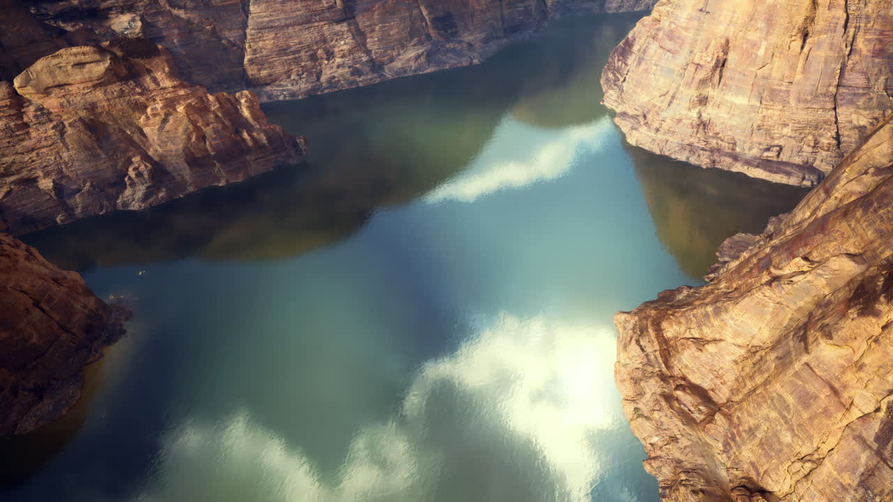 Serene waters reflecting sky amidst rocky canyon landscape in daylight