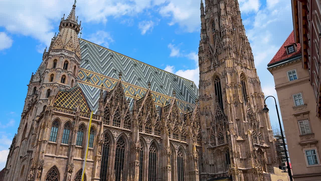 Vienna, Austria - June 9, 2025: Visit st. stephen's cathedral. Tourists admire the stunning architecture of St. Stephen's Cathedral in Vienna under a clear blue sky