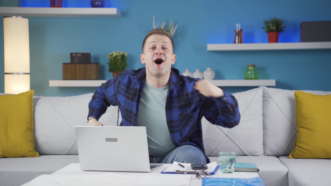 가정 사무실 노동자 남자가 카메라를 바라보며 기 ⁇ 을 경험하고 있습니다.