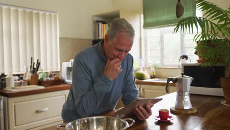 hombre mayor que usa una tableta digital en casa