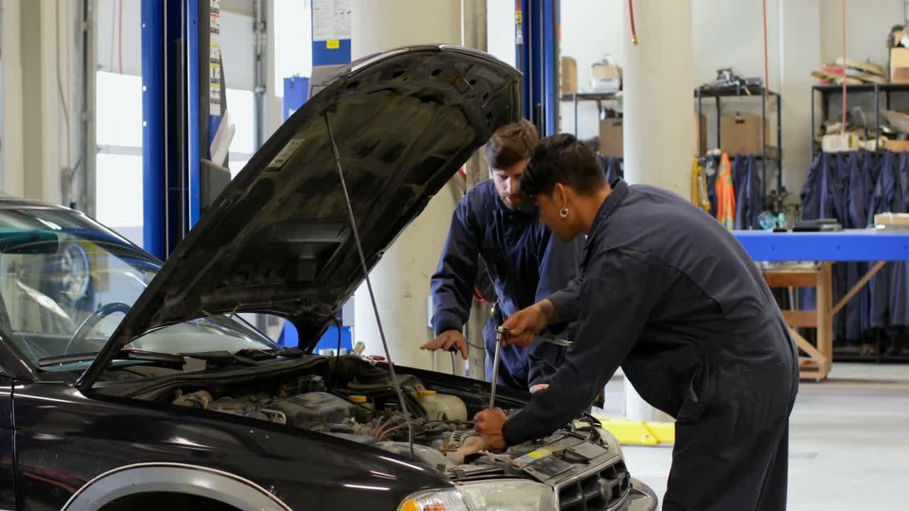 mecánicos reparando el motor del coche en el taller 4k