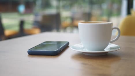 café y teléfono móvil en una mesa