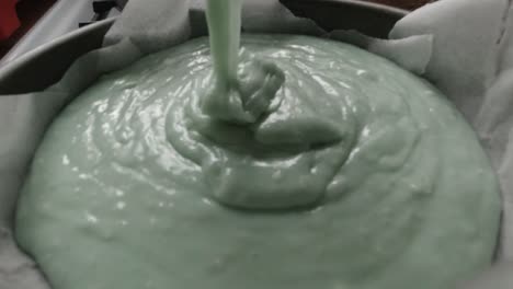 falling creamy smooth raw cake batter mixture into kitchen cooking pan