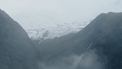 rugged rocky mountains background with copy space, atmospheric mood with moody mist and clouds, dramatic himalayas background with copyspace in muted desaturated nature background