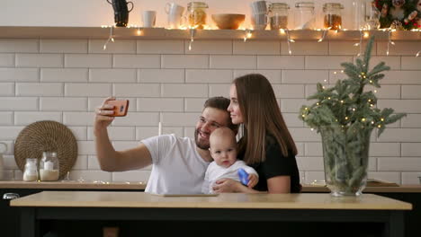 close up portrait of a happy couple taking a selfie with baby