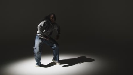 full length studio portrait shot of young woman dancing in spotlight 1