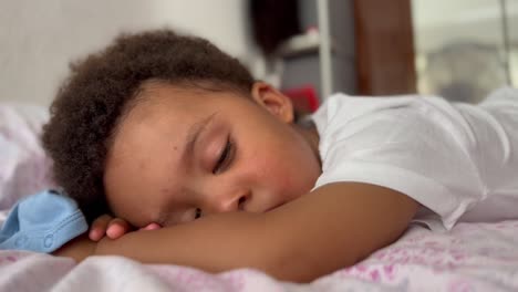 Adorable-and-exotic-two-year-old-child-awakening-from-his-summer-siesta-in-his-bed