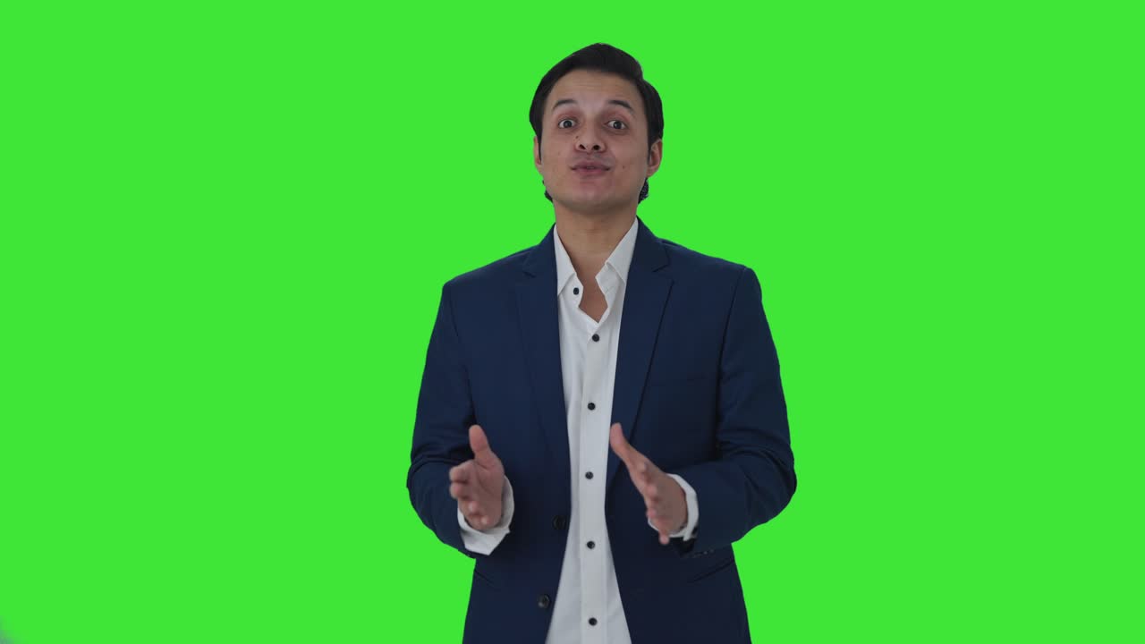 Happy Indian journalist reading news Green screen