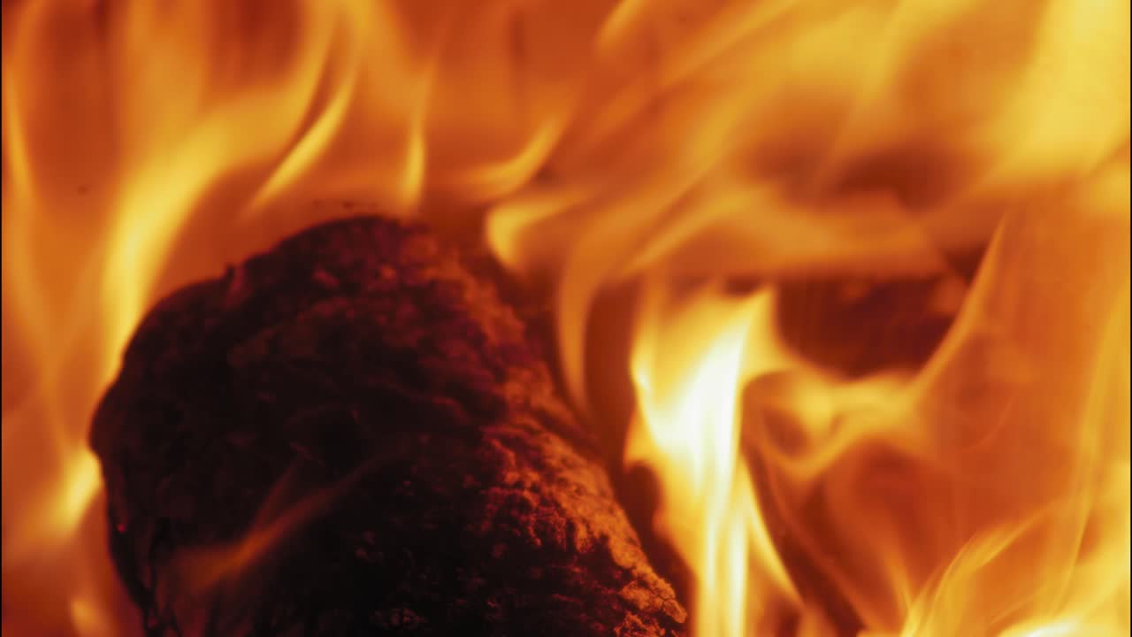llama ardiente en la chimenea en troncos de madera
