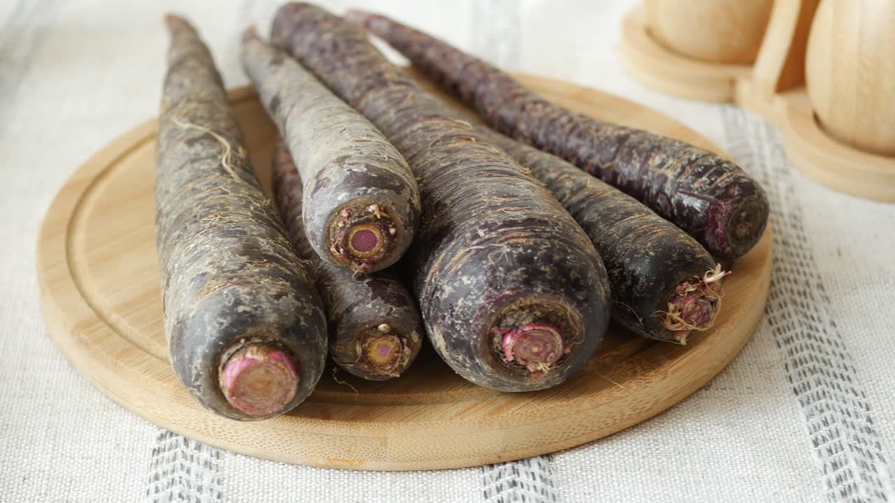 Purple Carrots on a Wooden Cutting Board