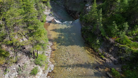 Flying-Down-a-River-Waterfall-into-Forest-Canyon