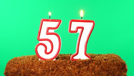 cake with the number 57 lighted candle. chroma key. green screen. isolated