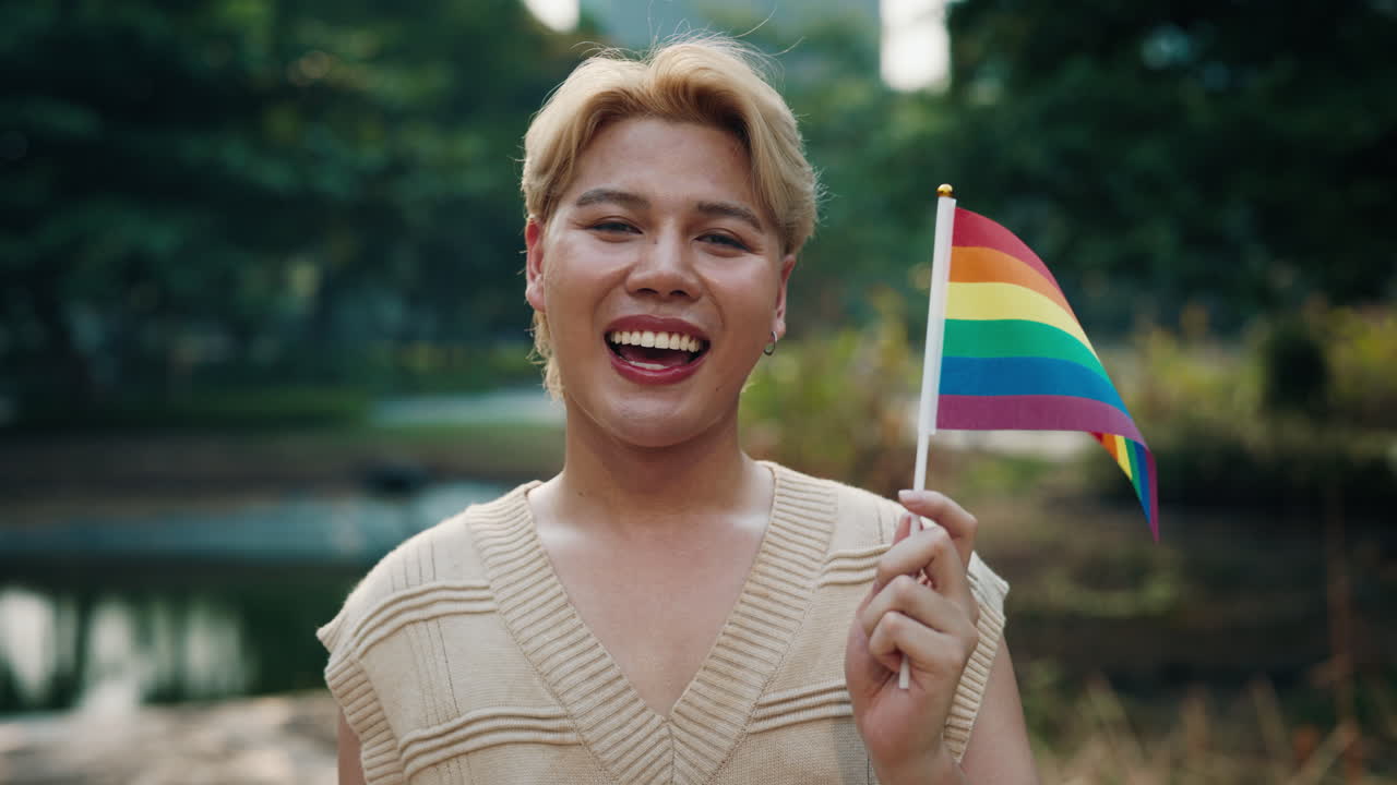 Person holding LGBTQ+ pride flag