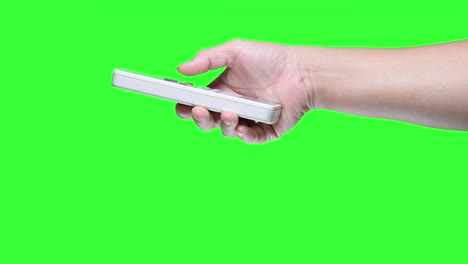 hand holding a remote control isolated on green screen background.