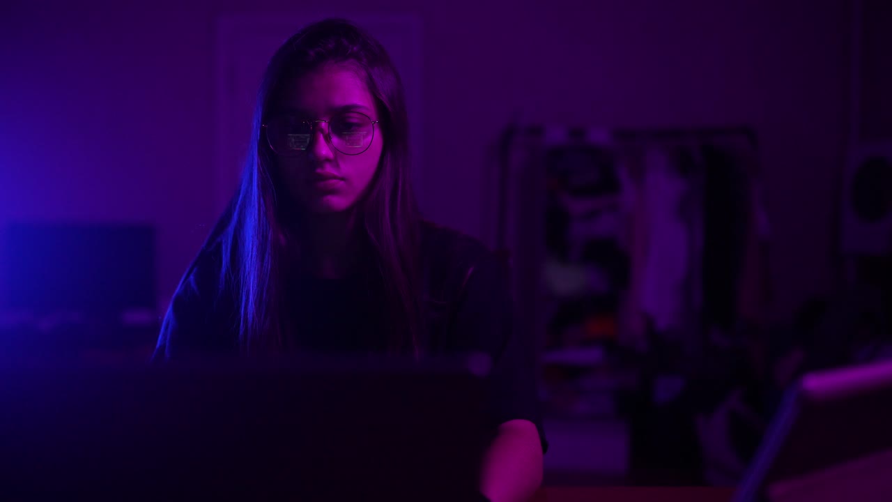 Teenager working on a laptop at night