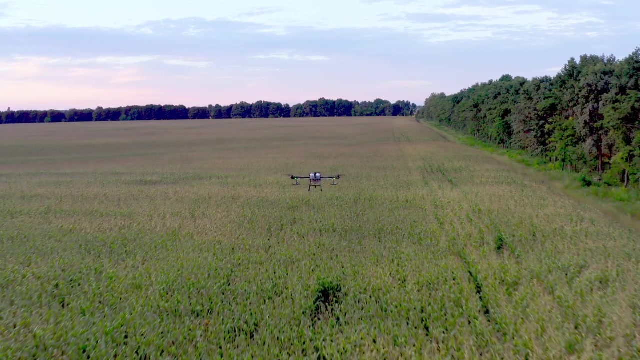 Drone agricolo che vola sopra un campo coltivato verde