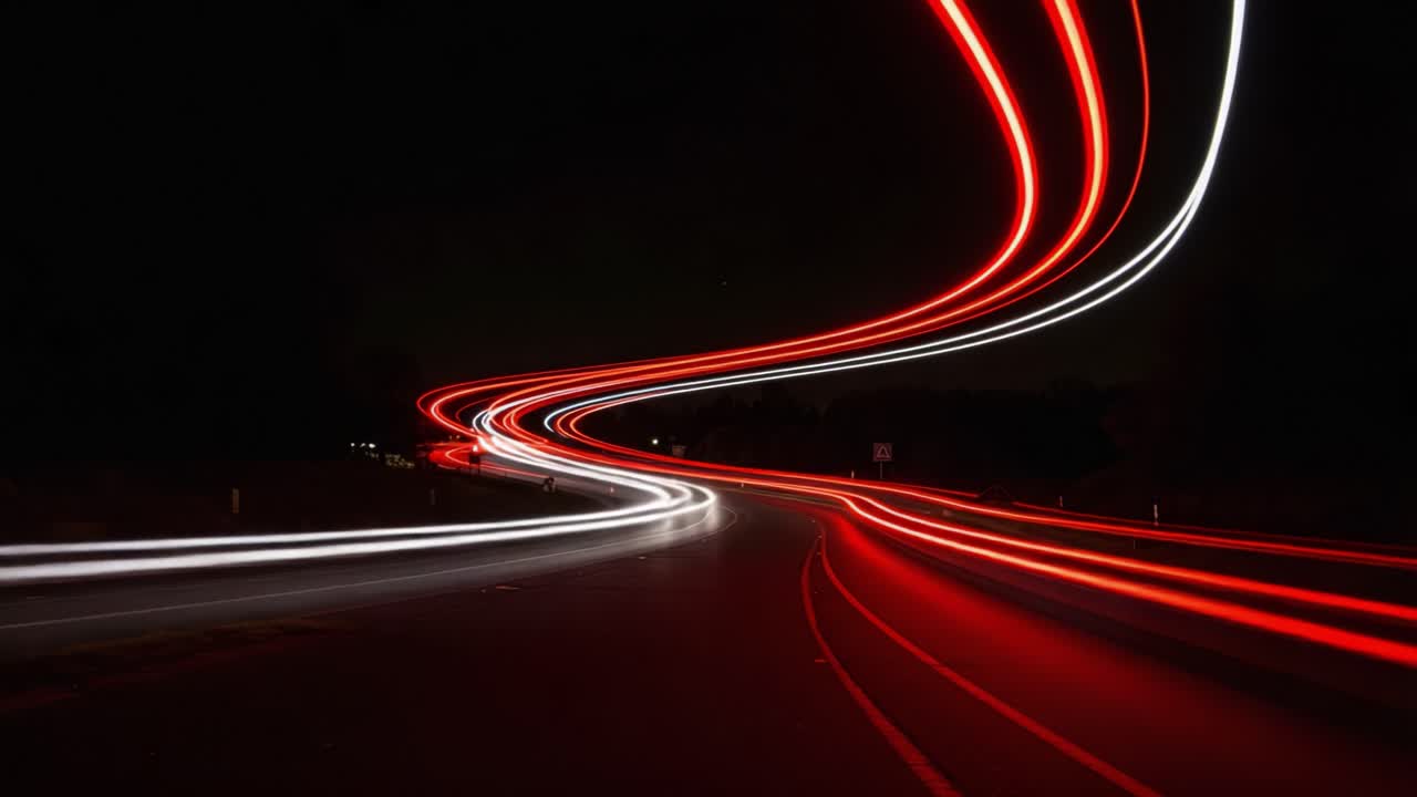 Captivating Light Trails on a Winding Road at Night, Showcasing the Dynamic Movement of Vehicles in Long Exposure Photography