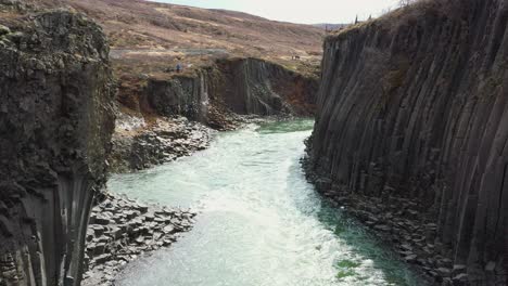 Flug-Durch-Basaltsäulen-Mit-Türkisfarbenem-Wasser-In-Der-Studlagil-Schlucht-In-Ostisland