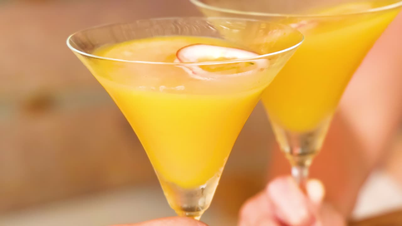 Close-up of two yellow cocktails in martini glasses, highlighting their vibrant color and refreshing appeal.