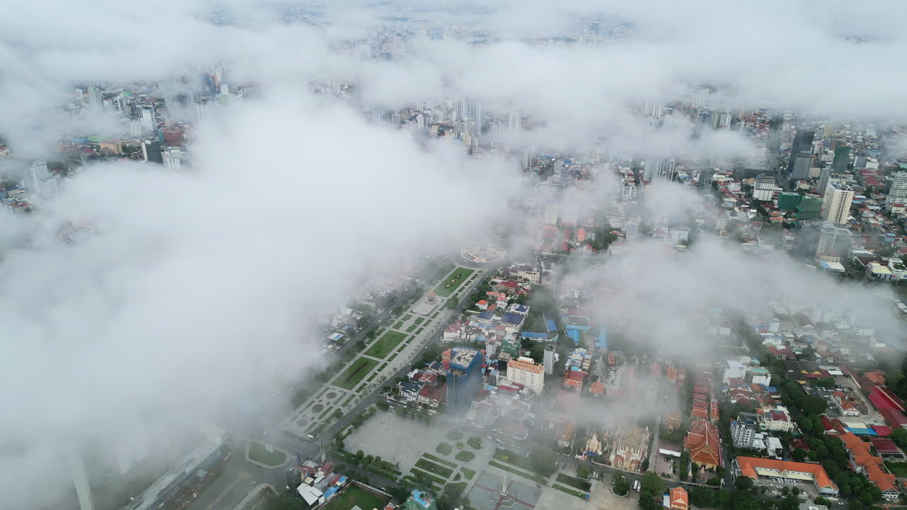 Aerial video of Phnom Penh shows clouds drifting over the city, with parks and boulevards peeking through the fog
