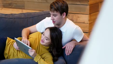 couple using digital tablet in living room