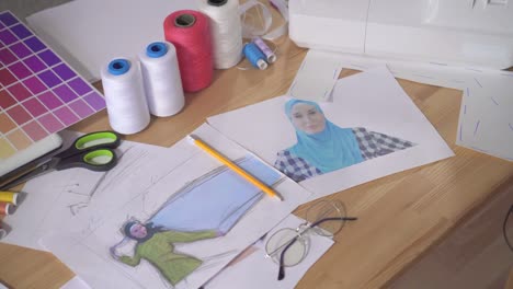 sketches of muslim clothing on the table in the designer's studio top view