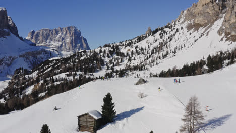 vista panorámica de la estación de esquí dolomitas con varios turistas esquiando en passua, italia