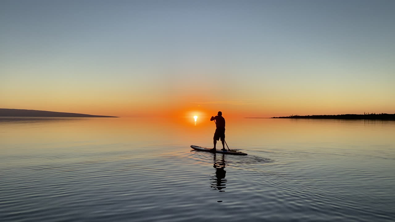 Paddleboard con uno sfondo al tramonto su un oceano incontaminato