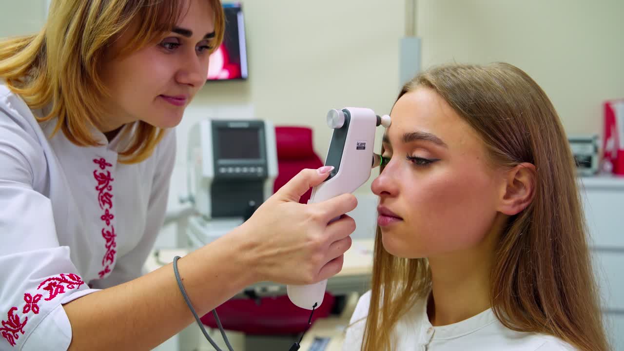 Beautiful woman at the ophthalmologist's consultation . Female specialist examines patient's eyes with a special device in modern medical center.